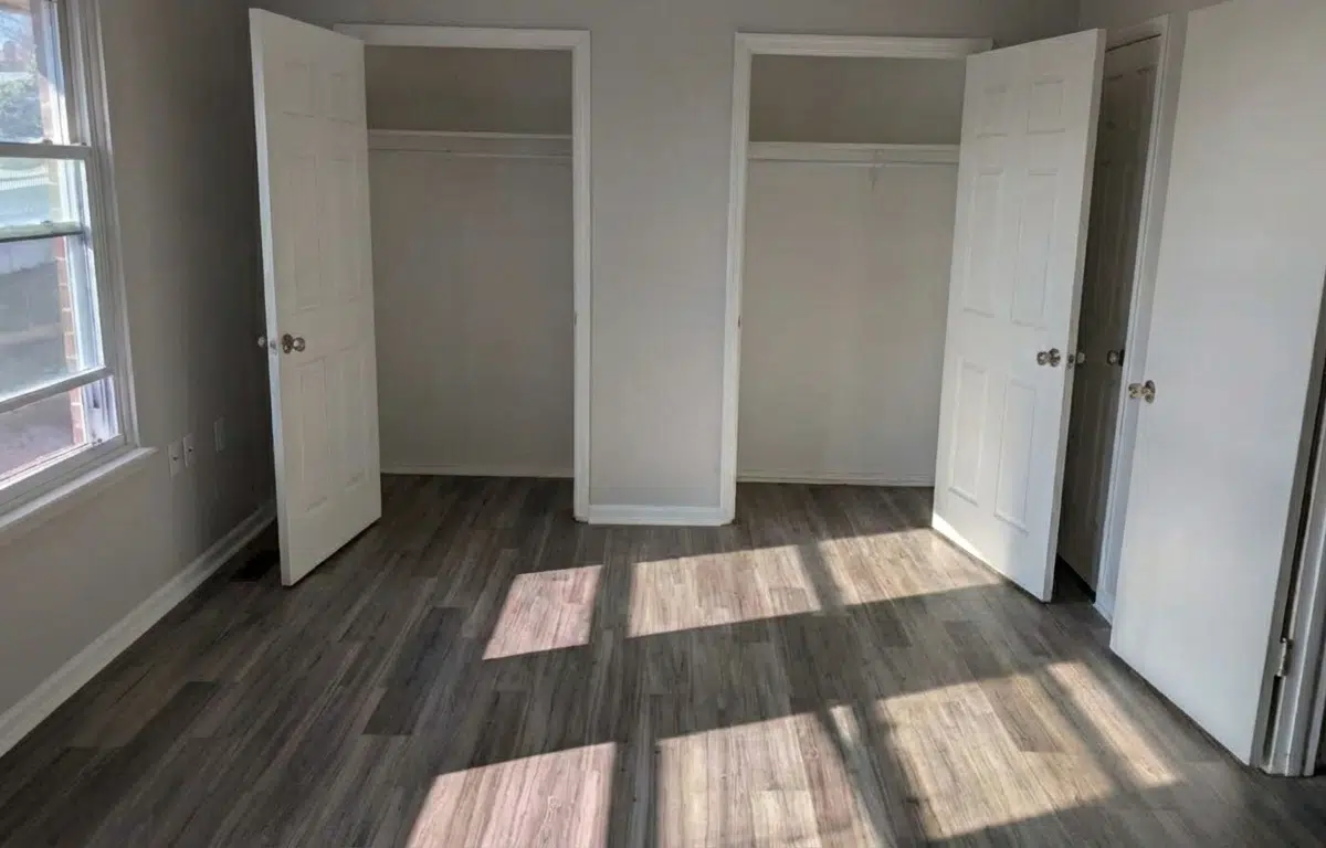 Bedroom with open window and two separate closets.