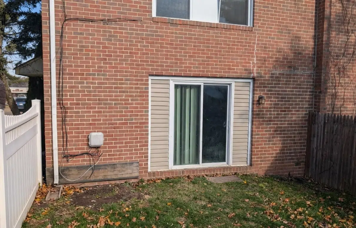 Townhome yard with grass and living room sliding glass door.