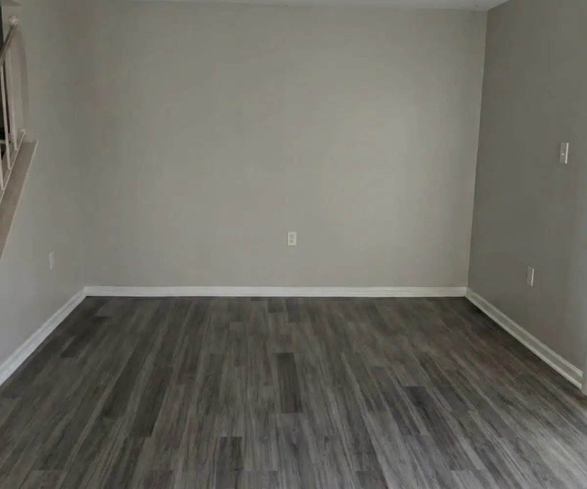 Living room with window blinds and stairs leading to the bedrooms.