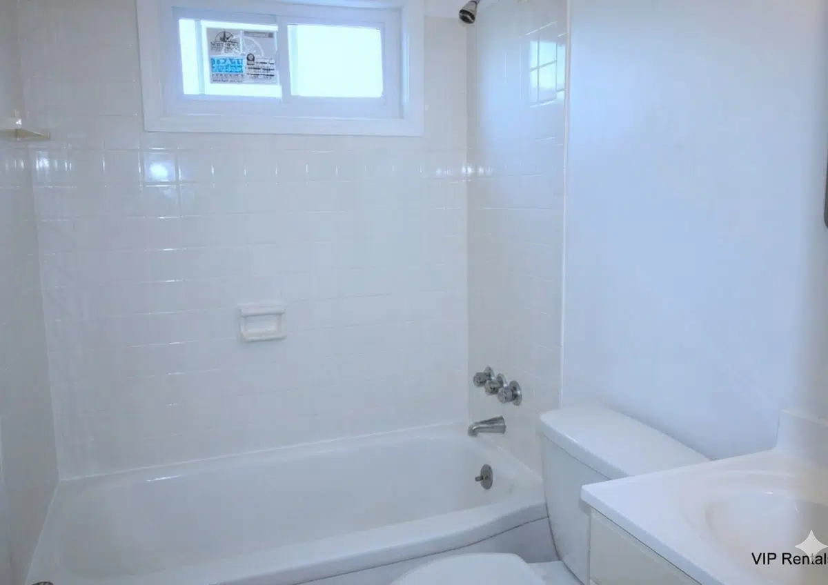 Bathroom with window, bathtub and toilet.