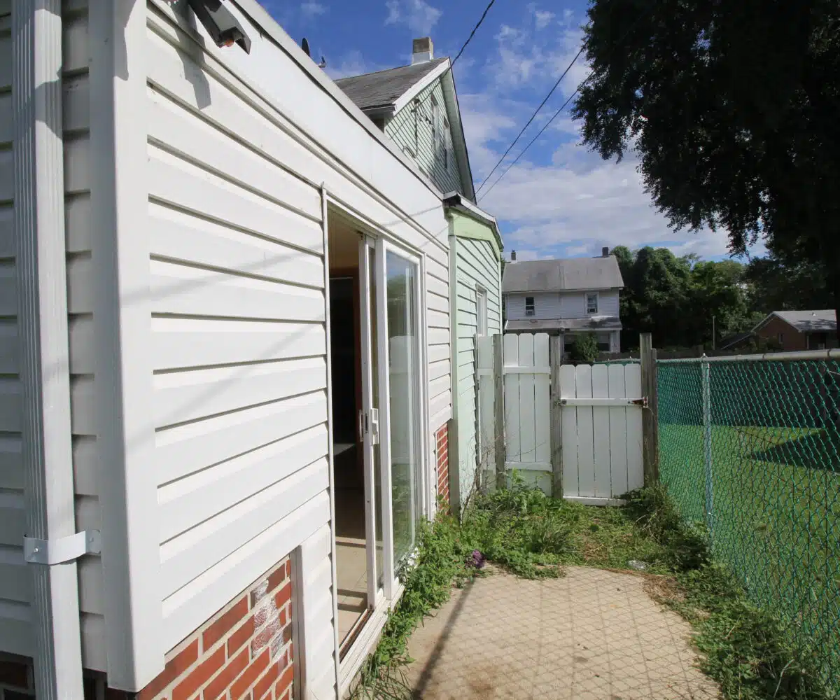 Small patio with concrete floor next to sliding glass doors.