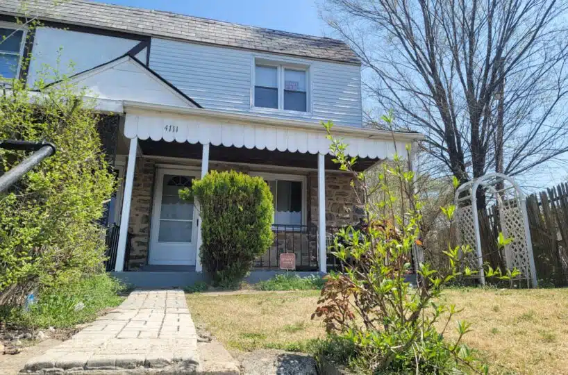 Townhouse exterior with brick path leading to white front door.
