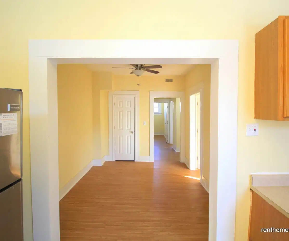 Kitchen and dining room with yellow walls and ceiling fan.