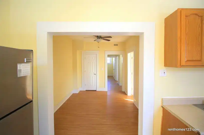 Kitchen and dining room with yellow walls and ceiling fan.