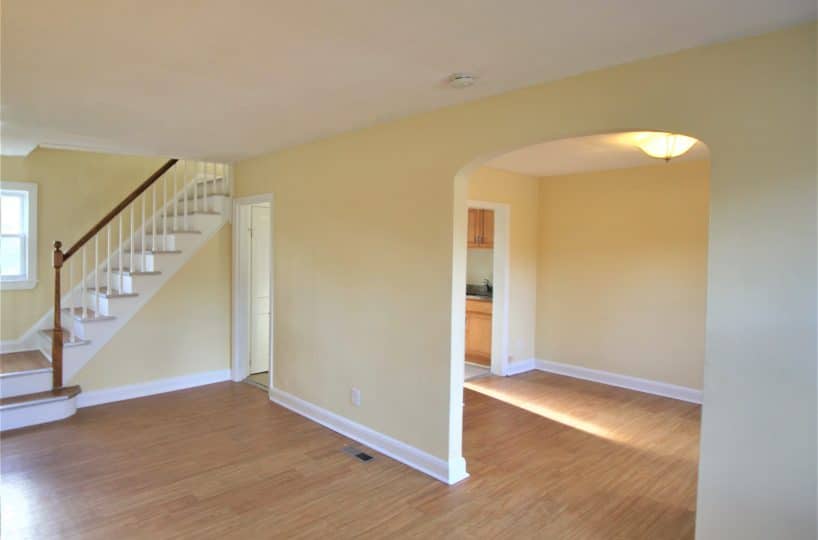 Living room with yellow walls and wood floor and dining room