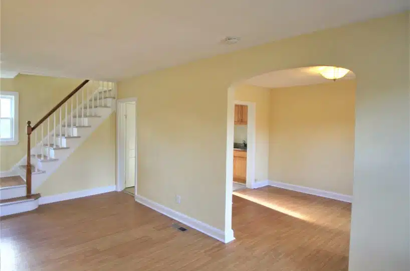 Living room with yellow walls and wood floor and dining room