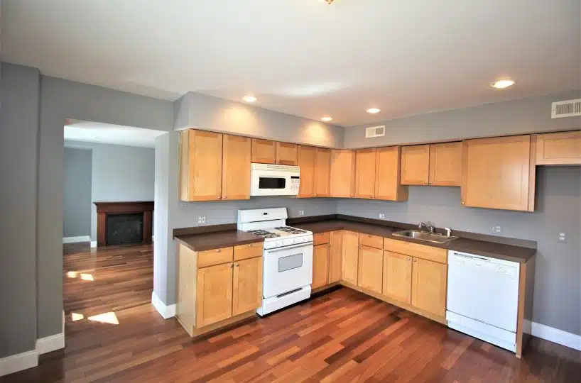 743 S Montford Ave kitchen with tri-color wood flooring, wood cabinets, stove and dishwasher.
