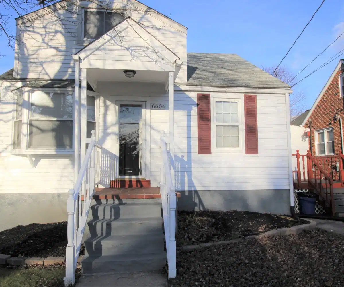 Home with white siding and red window shutters.