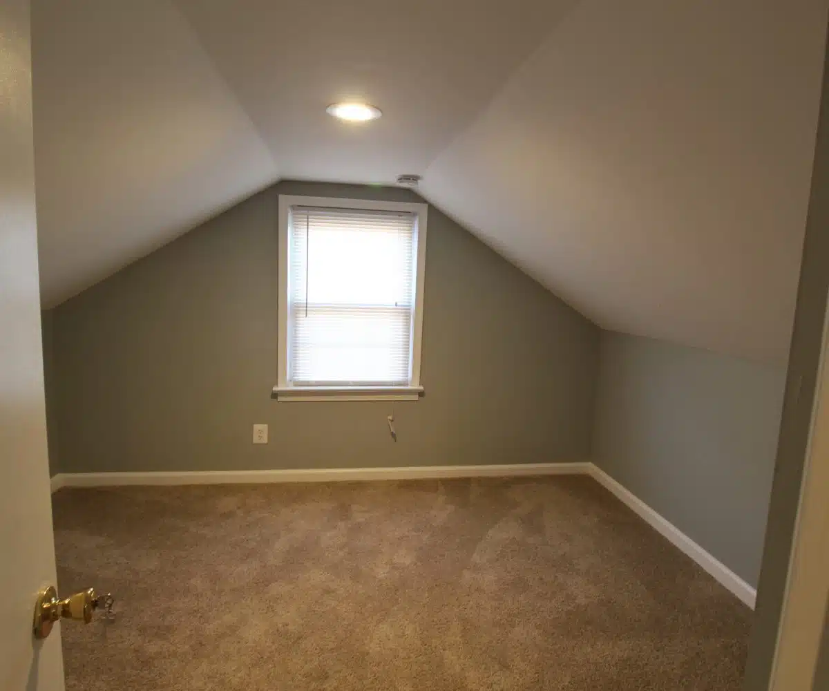 Bedroom with carpet, window and white blinds.