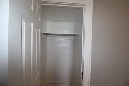 White closet with shelf.