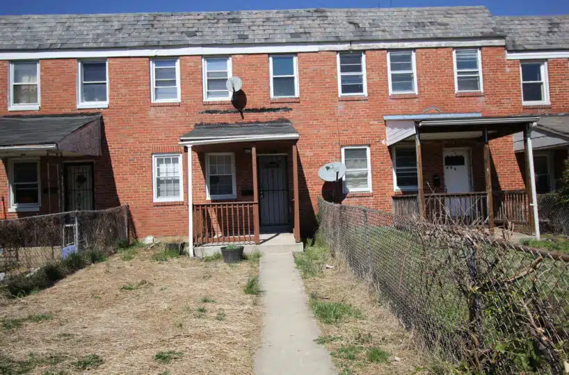 Fenced-in backyard of red brick townhome.