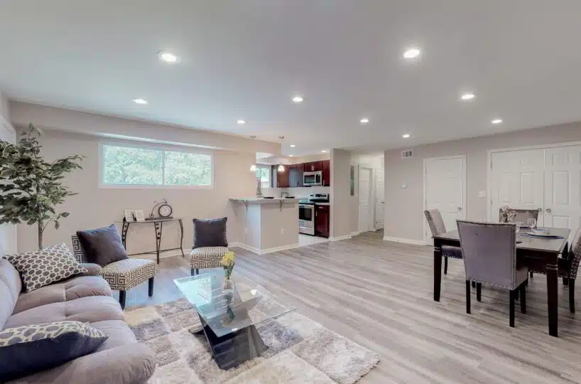 Living room with couch, rug and view of kitchen.
