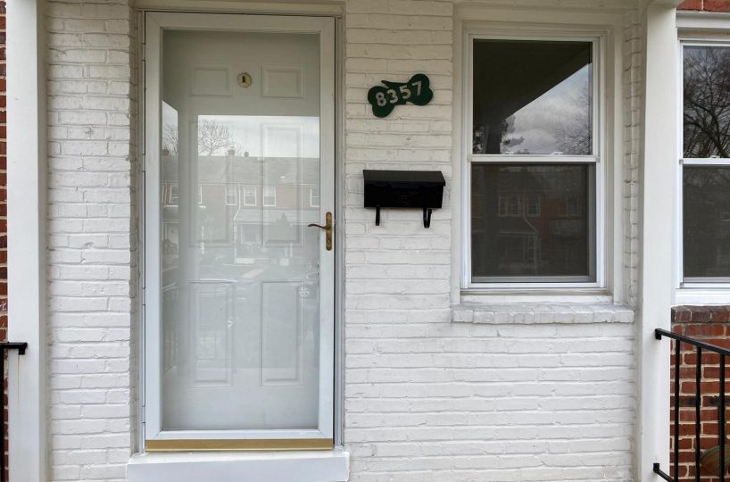 White brick townhome with white front door.