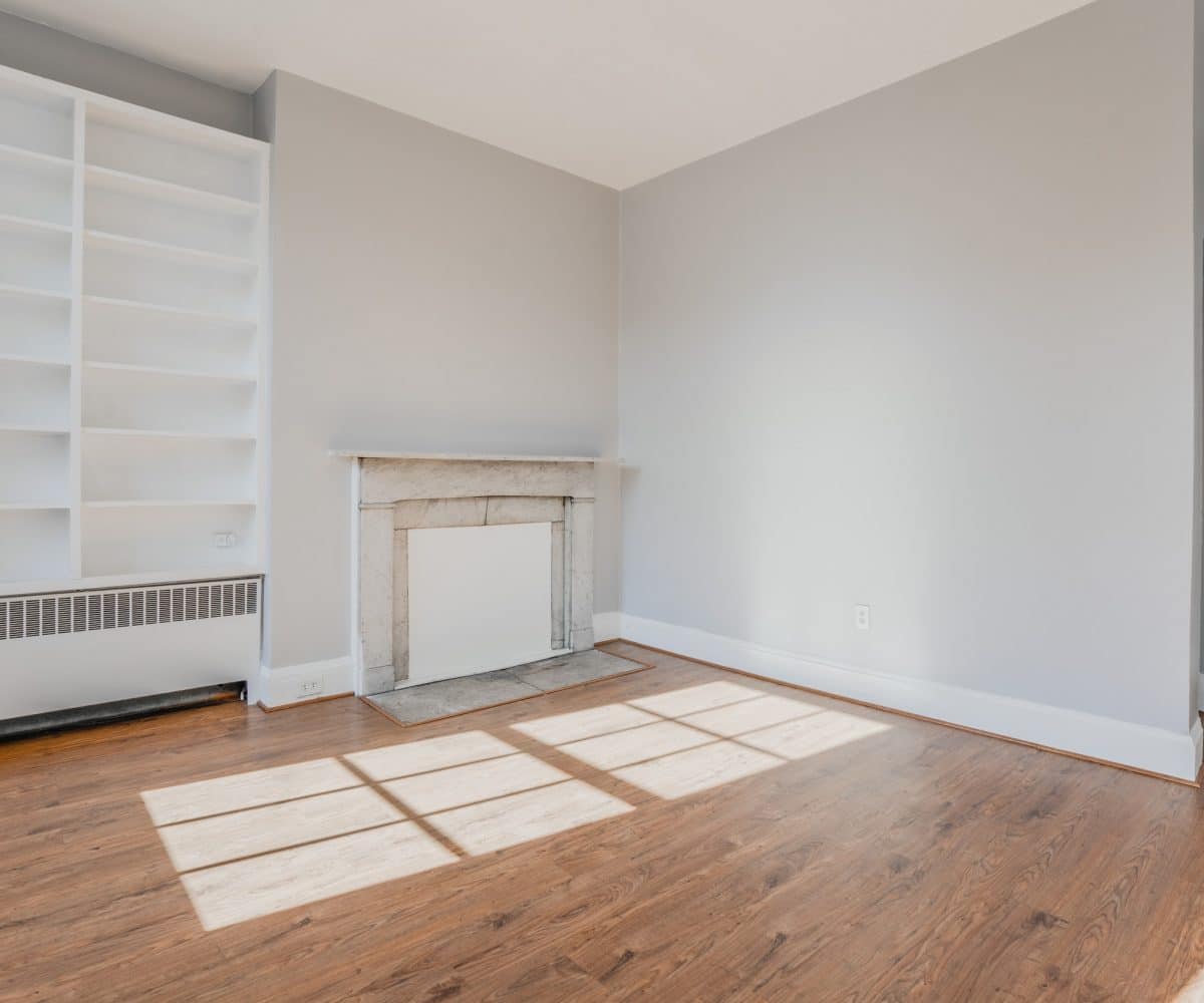Living room with built-in shelving, fireplace and hardwood floors.