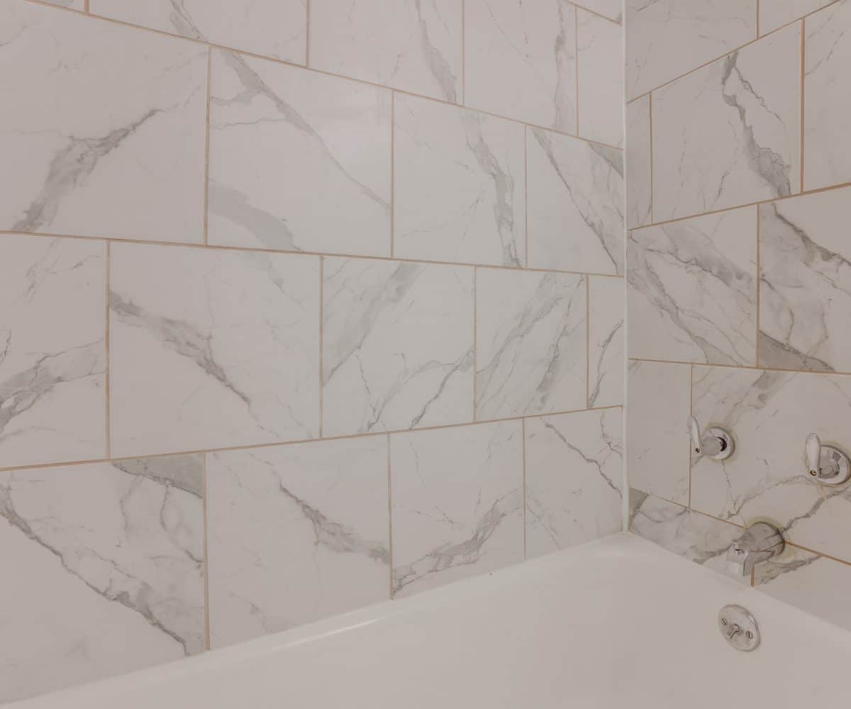 Bathtub with black and white tiles.