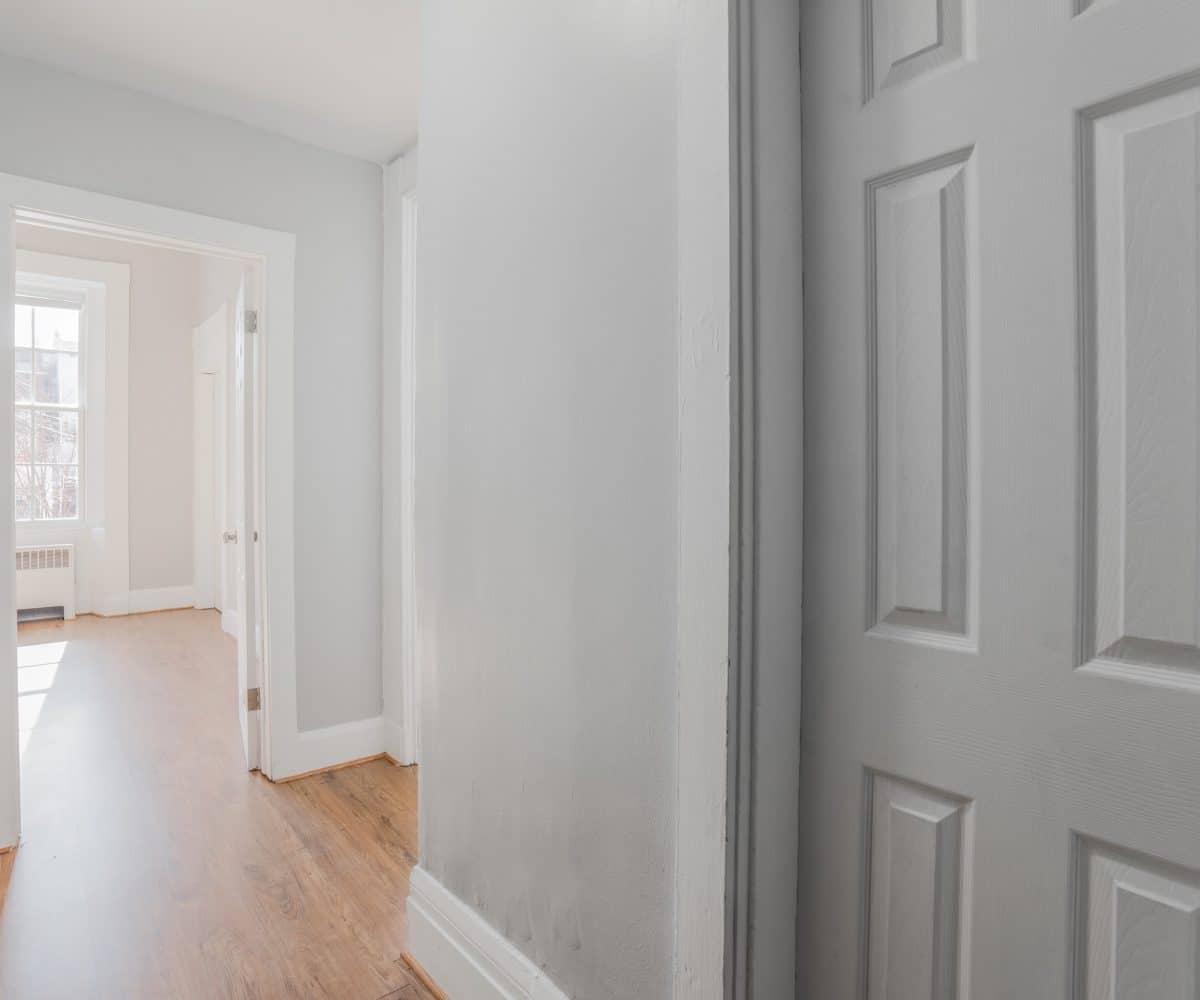 Hallway with hardwood floor and grey walls.