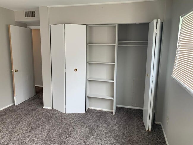 Bedroom with carpet and closets.