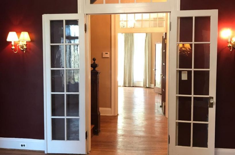 Living room with hardwood floors and glass doors.