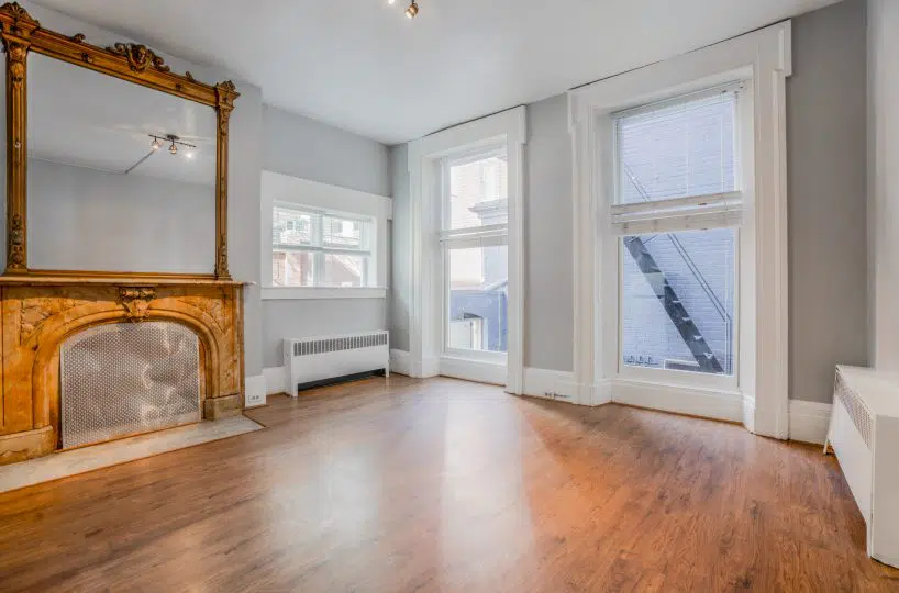 Living room with wood floor and large windows.