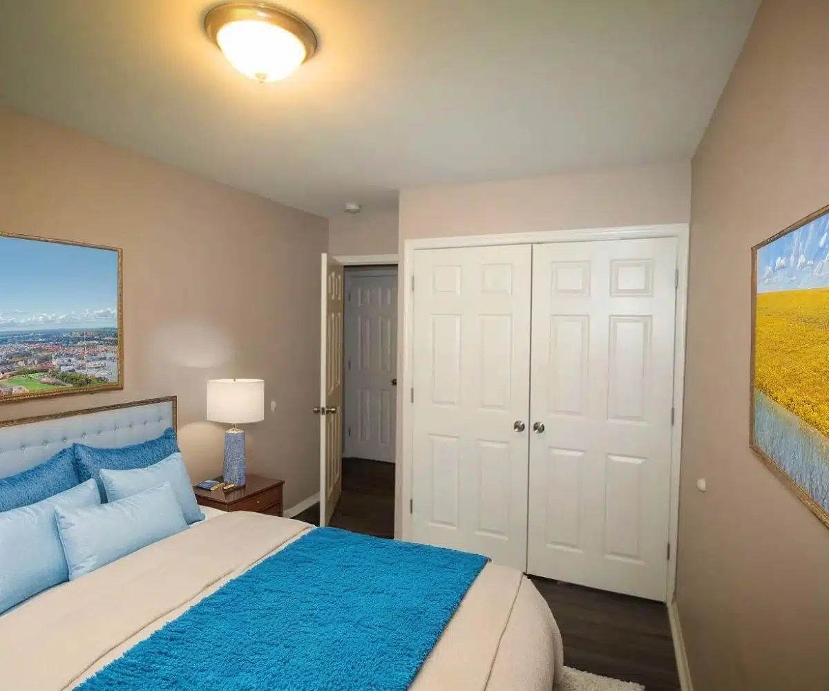 Bedroom with double bed, ceiling light and closet doors.