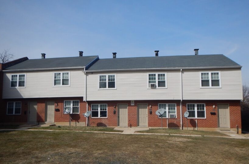 Oakford Townhomes exterior with red brick front and beige siding.
