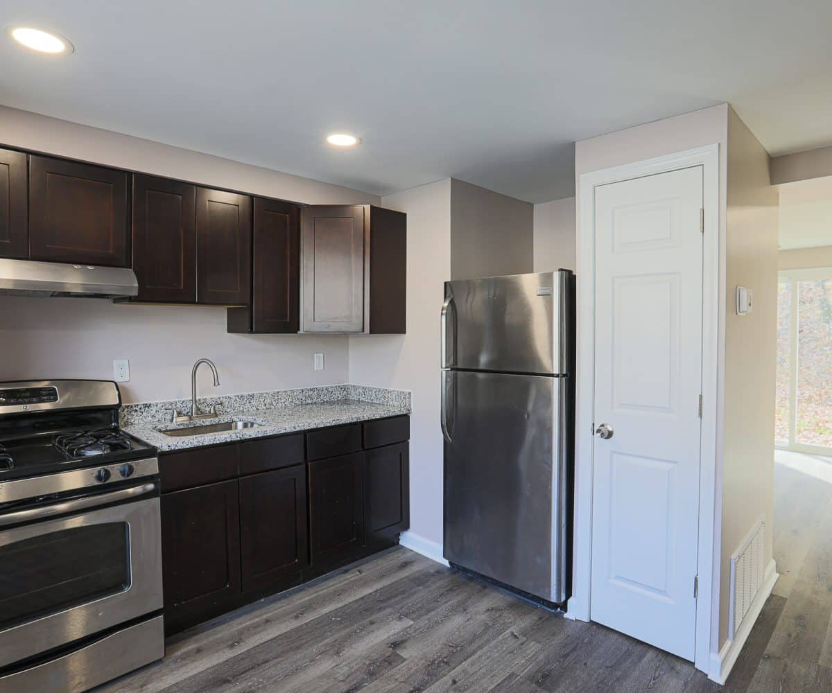 Kitchen with stainless steel appliances and grey flooring.