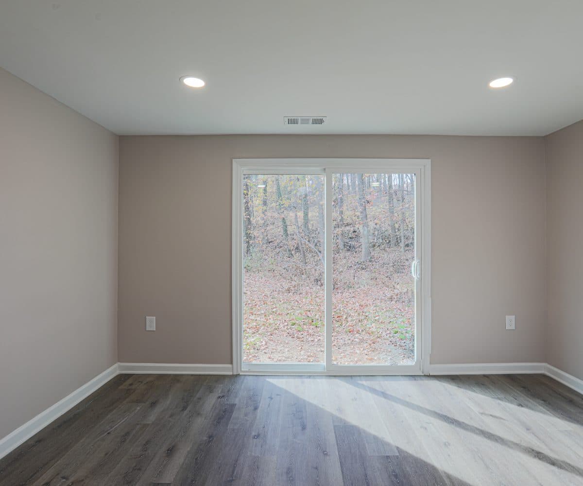 Living room with grey flooring and sliding doors.