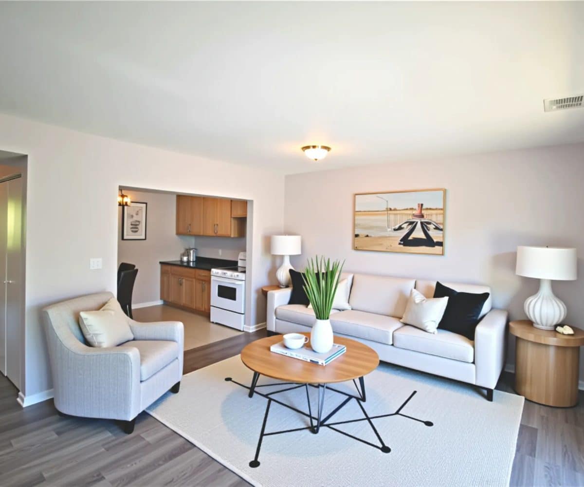 Living room with off white sofa and easy chair and coffee table.