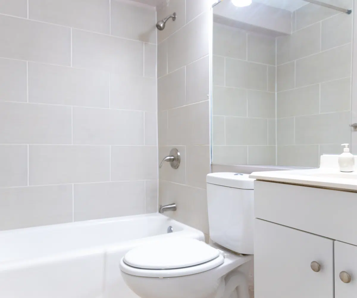 Tiled bathroom, bathtub and white toilet.