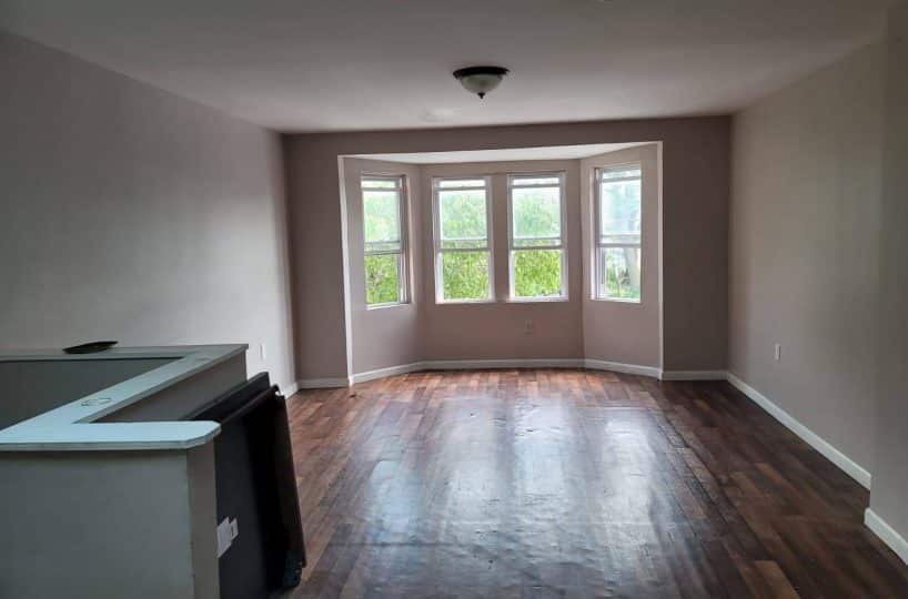 Bay window in living room with hardwood floors.