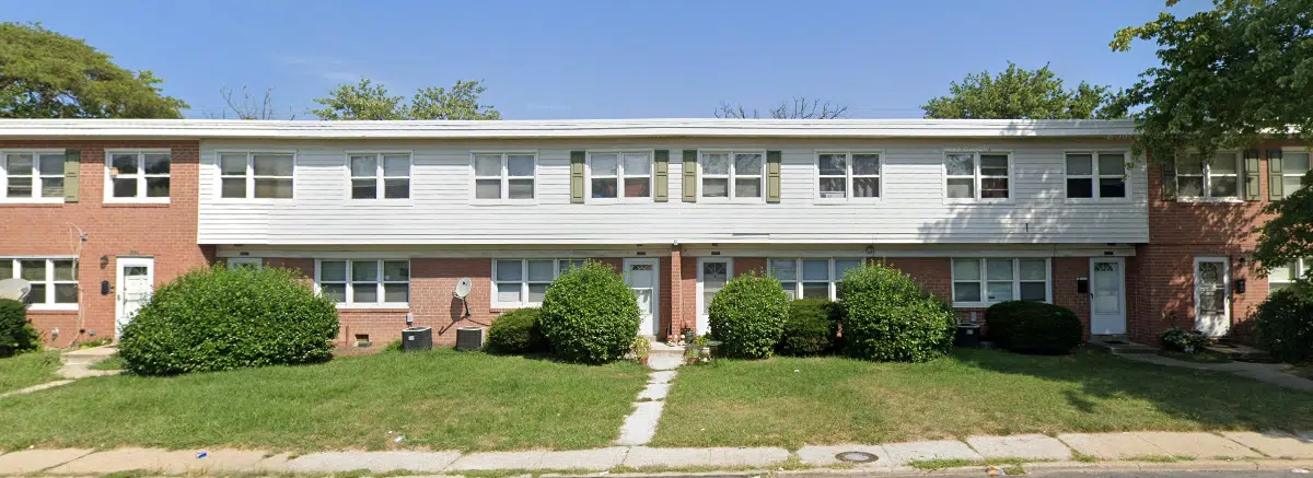 Exterior of Alameda Townhomes with red brick and beige siding.