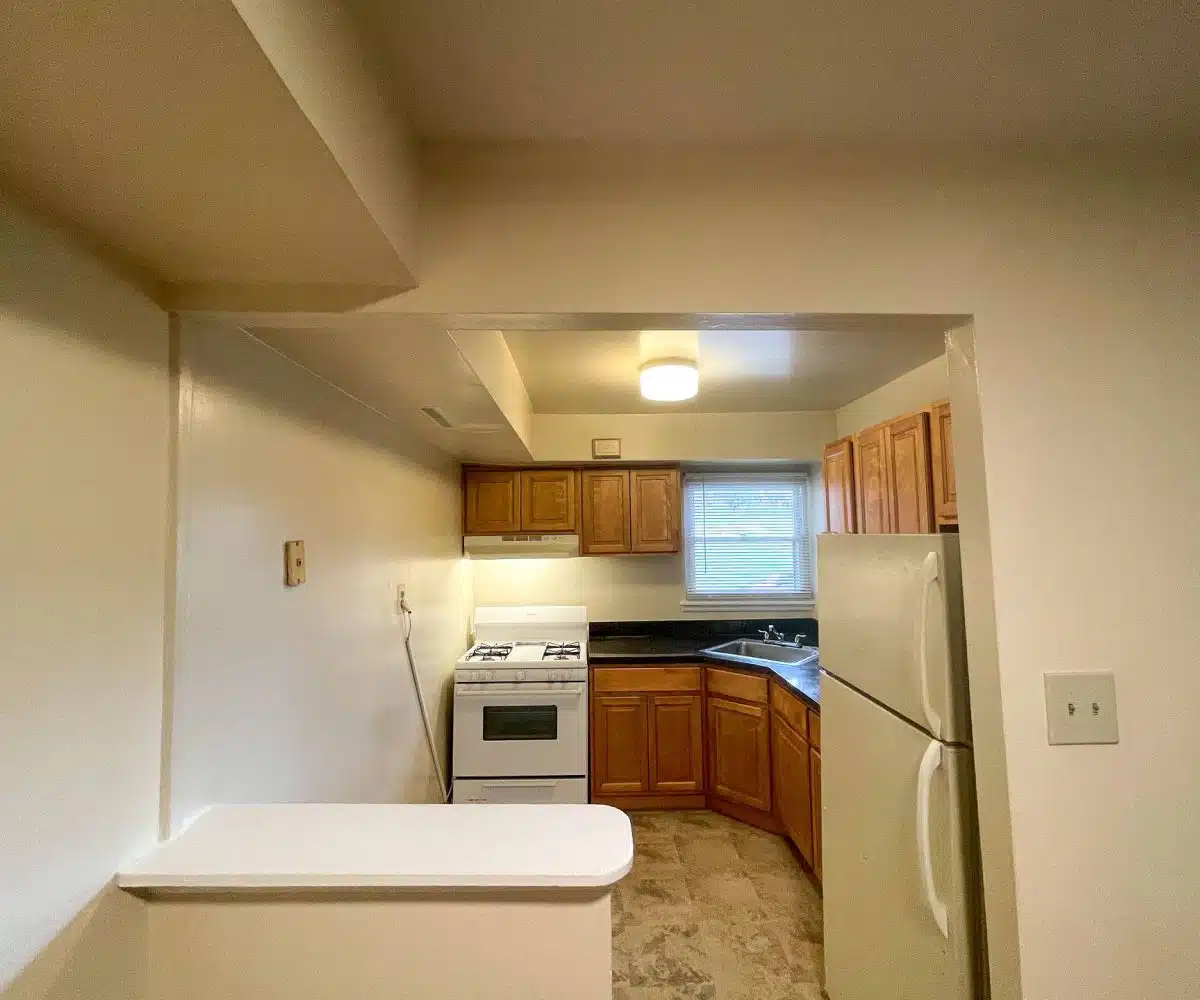 A well-lit kitchen with stainless steel appliances, including a stove, refrigerator, and sink.