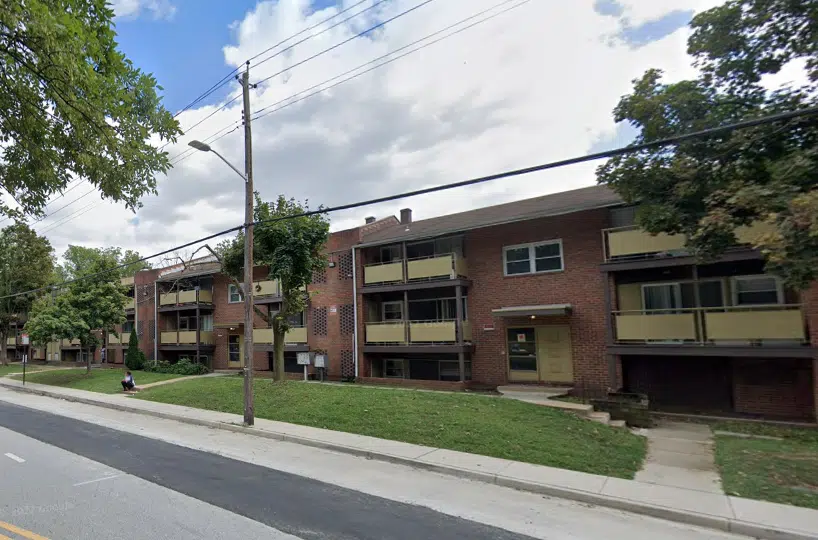 A row of brick apartment buildings with green grass.