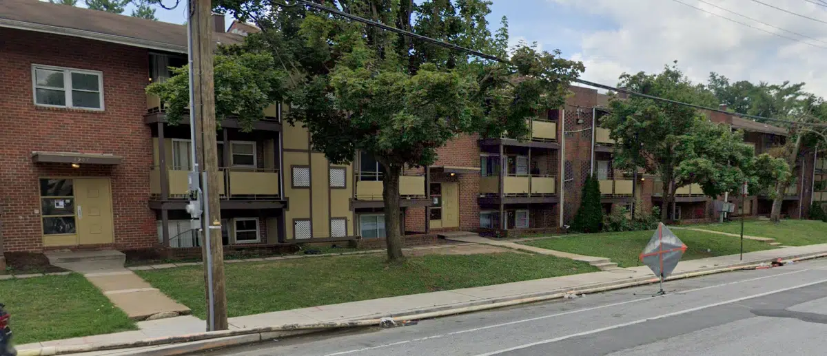 Brick apartment building with yellow front doors and yellow balconies.