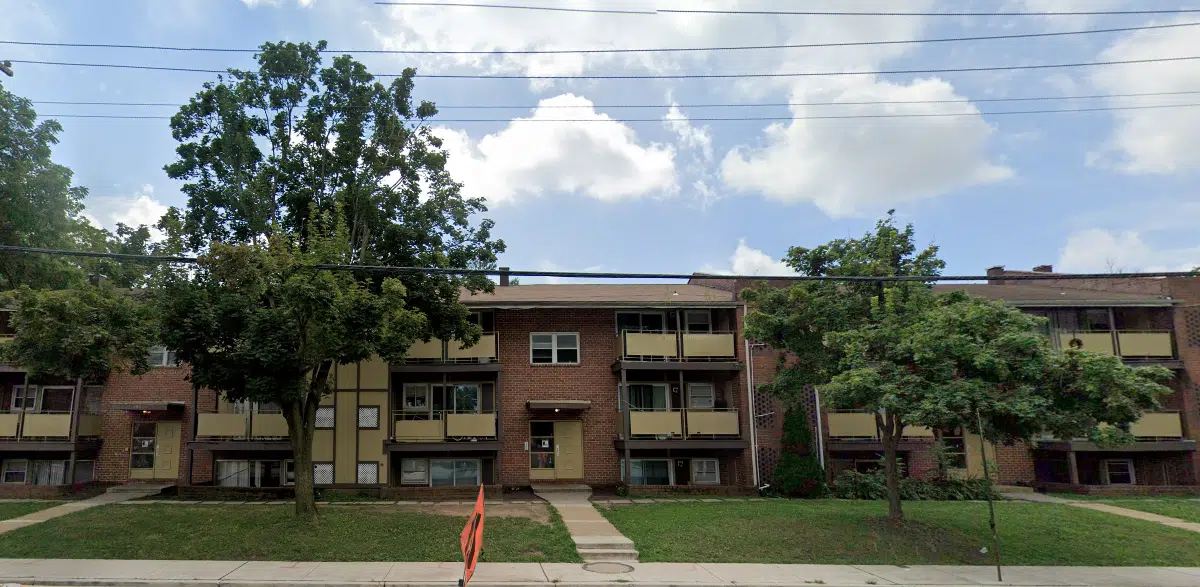 A brick apartment building with trees in front of it.