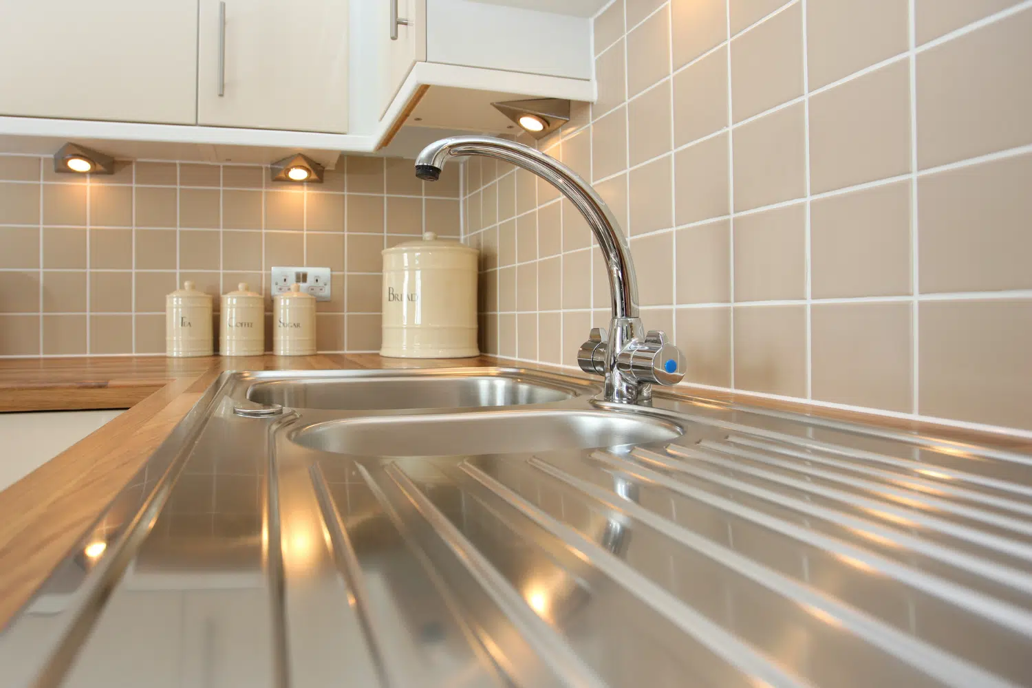 Shiny stainless steel sink and faucet.
