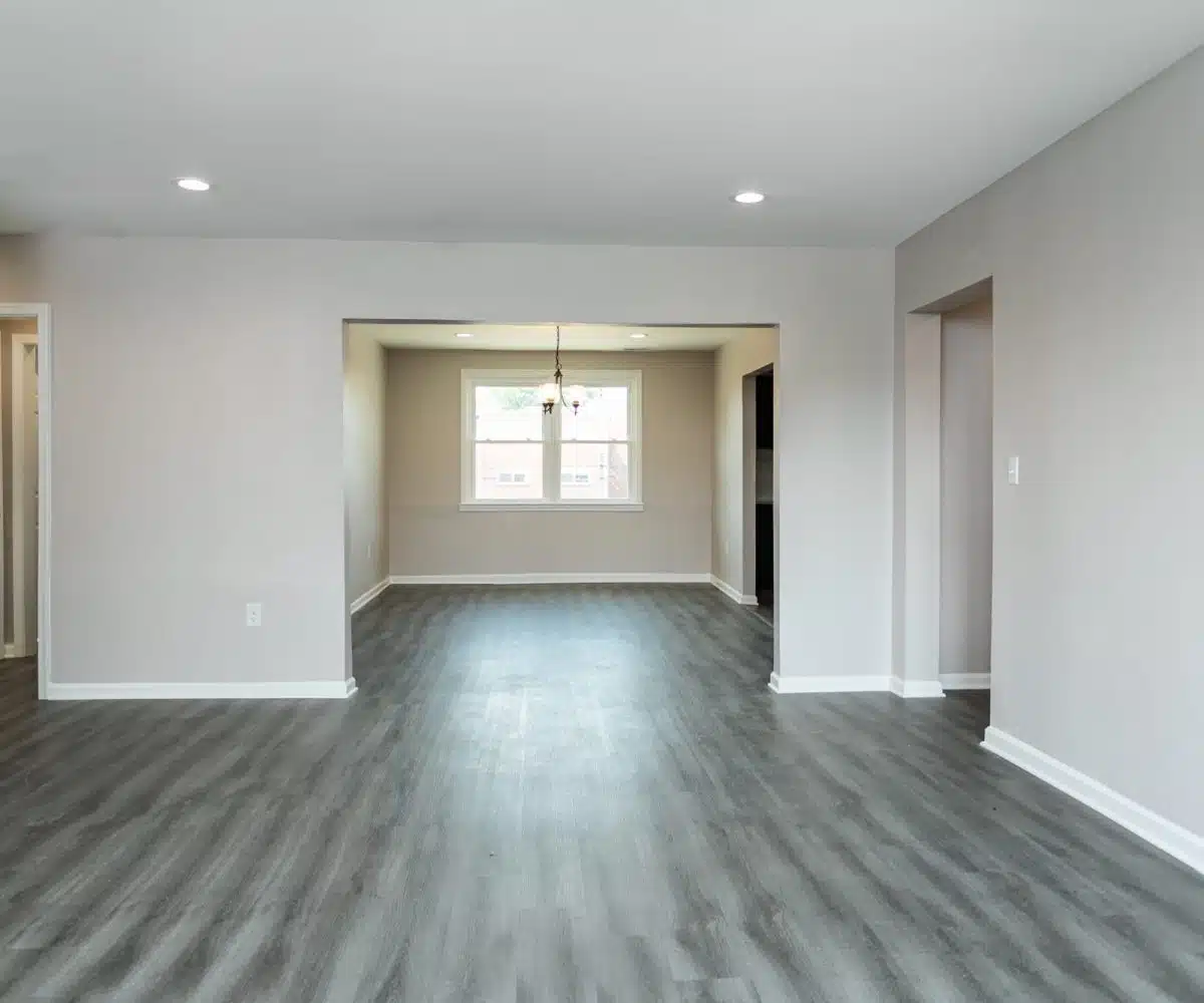 Bancroft Court Apts living room and dining room with spotlights and grey allure flooring.