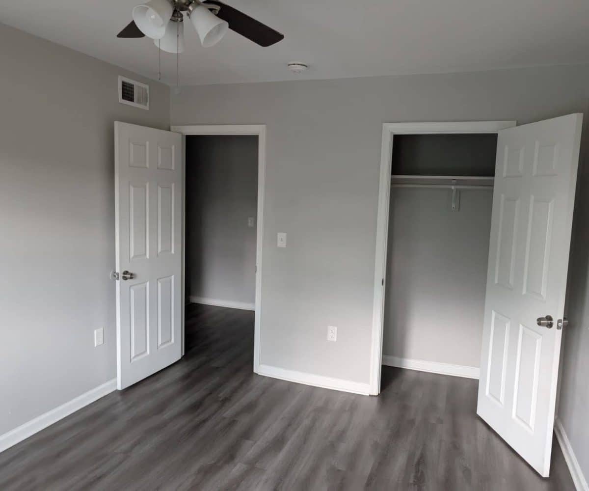 Alameda Townhomes bedroom with closet and ceiling fan.