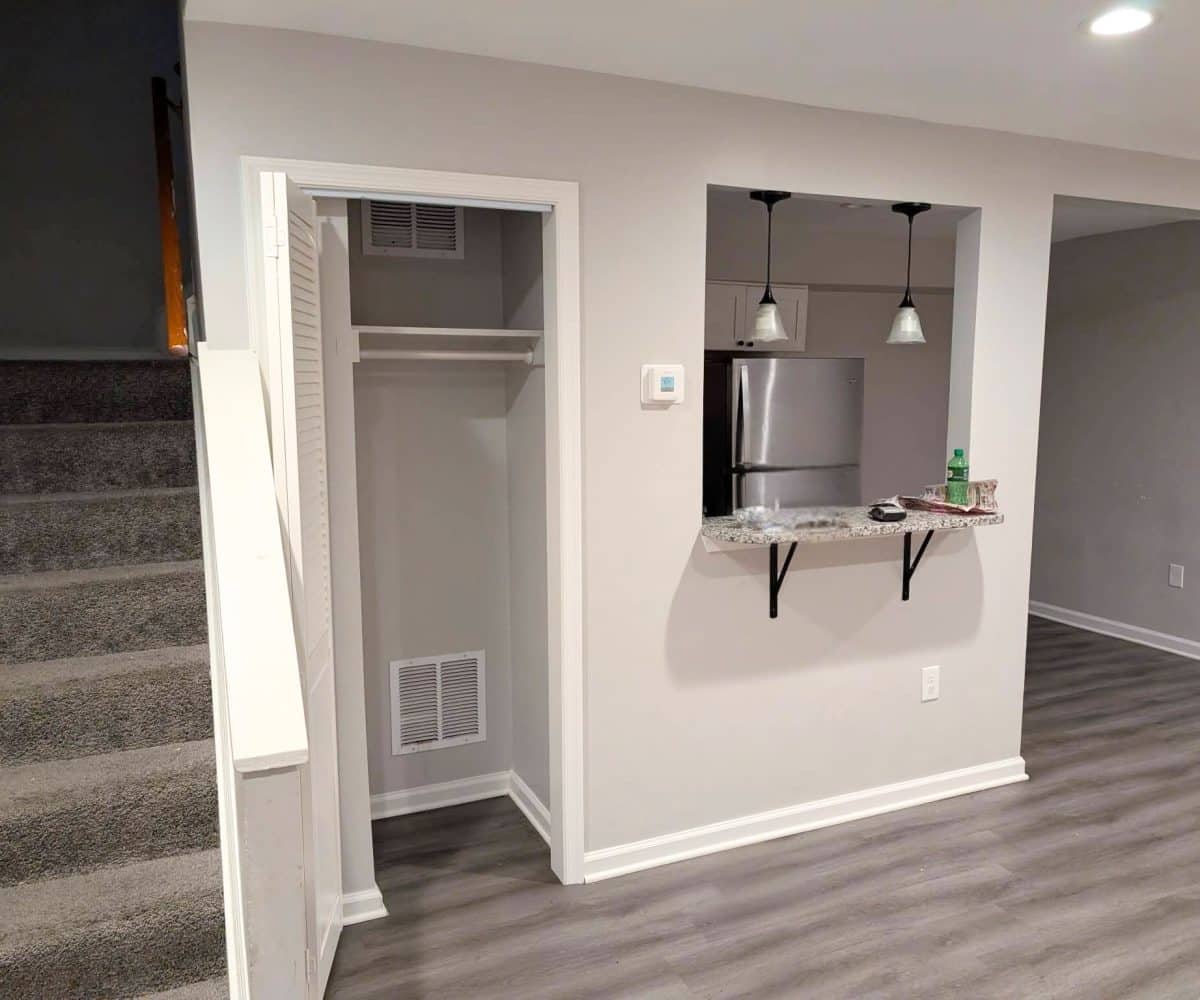 Alameda Townhomes living room with closet and carpeted stairs leading to the second floor.