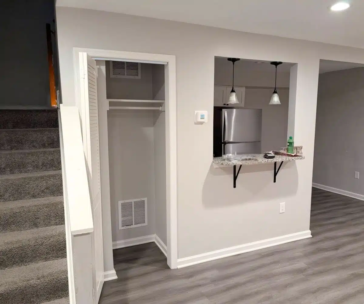 Alameda Townhomes living room with closet and carpeted stairs leading to the second floor.