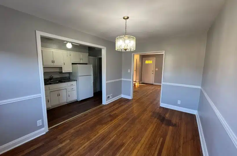 Dining room with hardwood floors and view of kitchen.