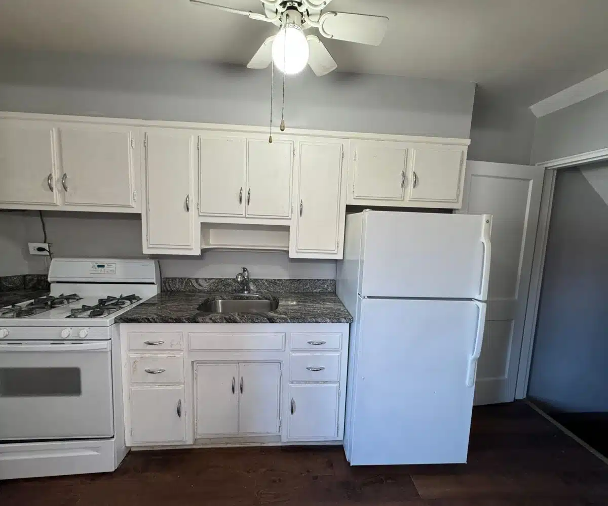 Kitchen with hardwood floors, white cabinets, a white stove and a white refrigerator.