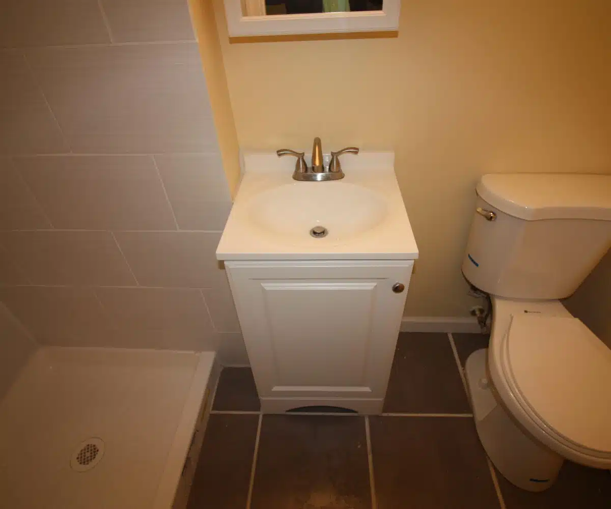 Bathroom with toilet, sink, and shower.