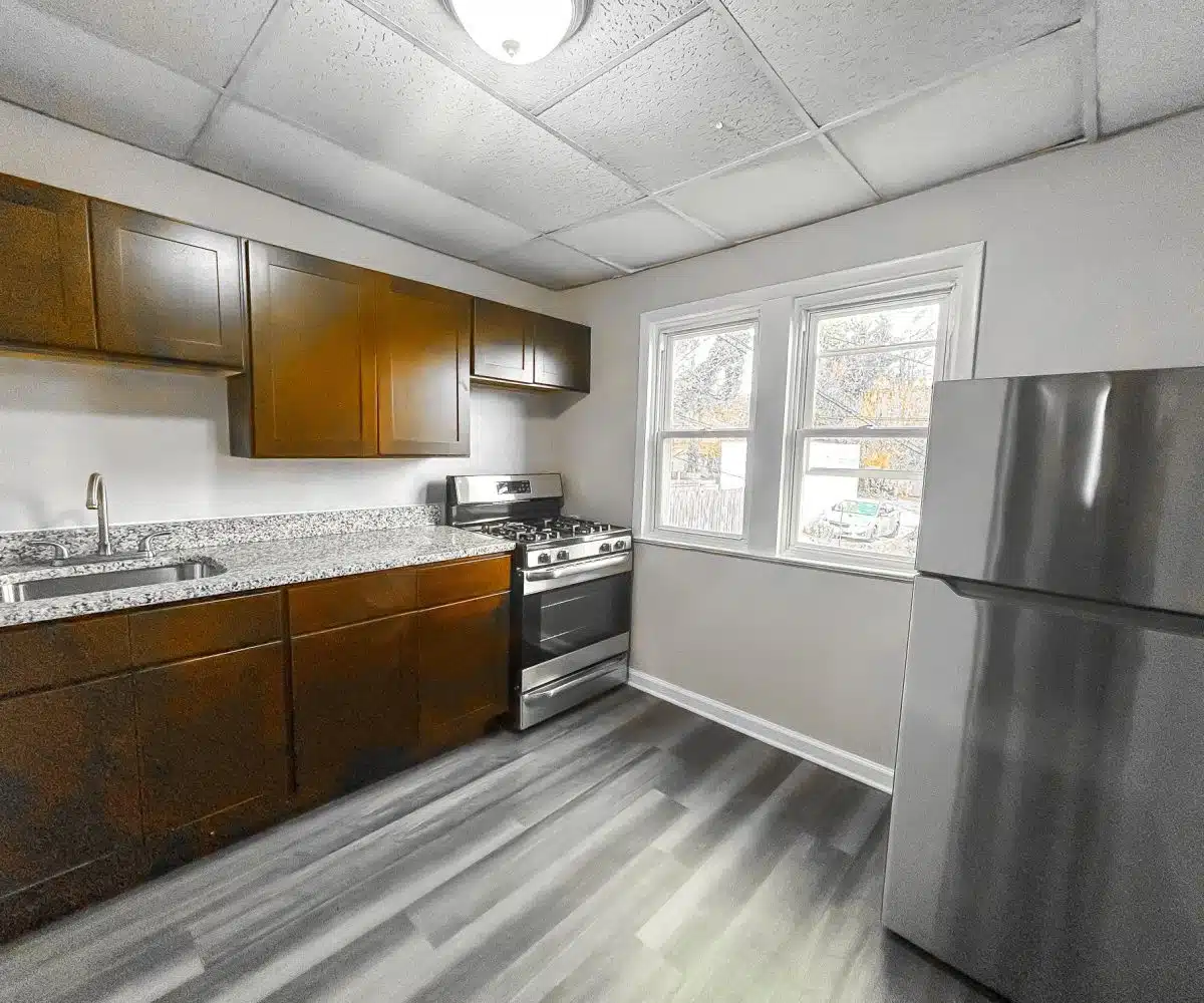 2421 Calvert kitchen with a granite countertop, ceiling light, oven and refrigerator.