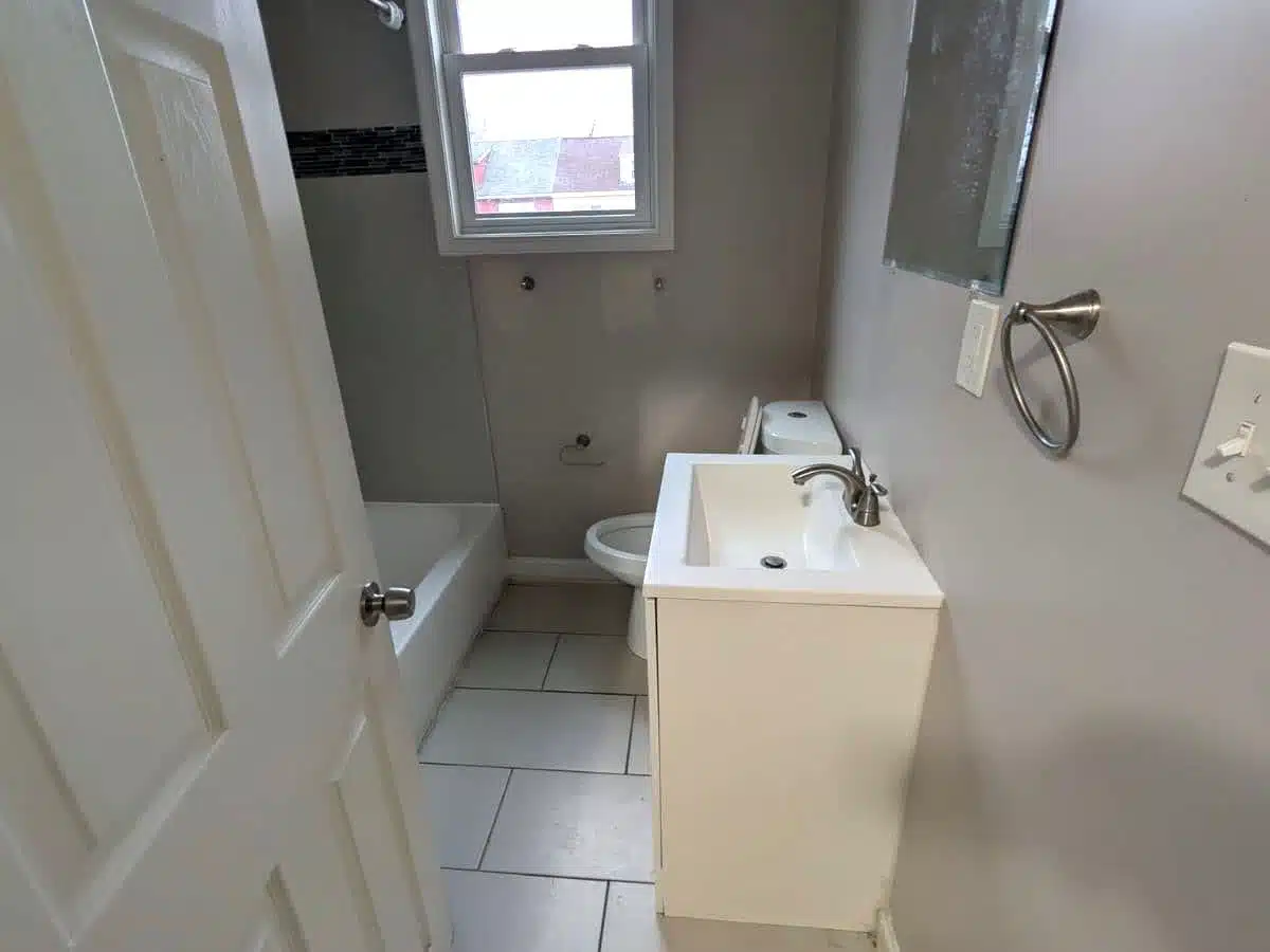 Bathroom with tub, toilet and sink in Baltimore townhome.