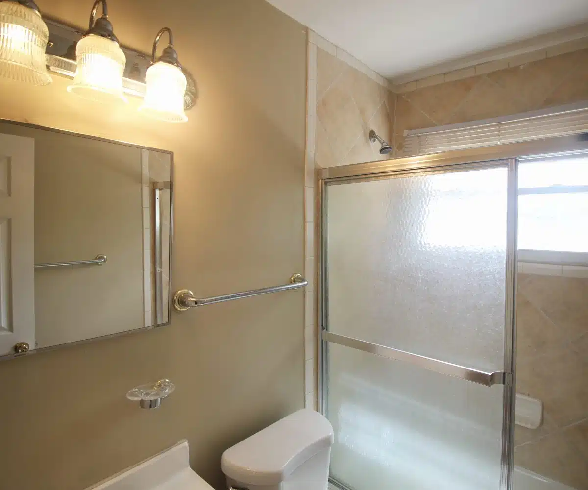 Bathroom with mirror, bathtub, toilet, and sink.